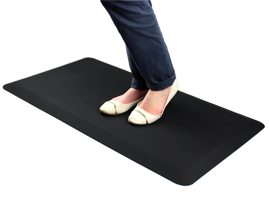 Woman using a Hometex anti-fatigue comfort mat while wearing flat pumps