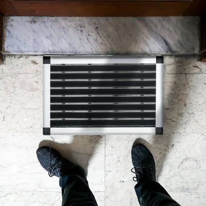 Person about to step onto the Hometex Premium Aluminium Outdoor Entrance Mat placed by a front door in a lifestyle setting